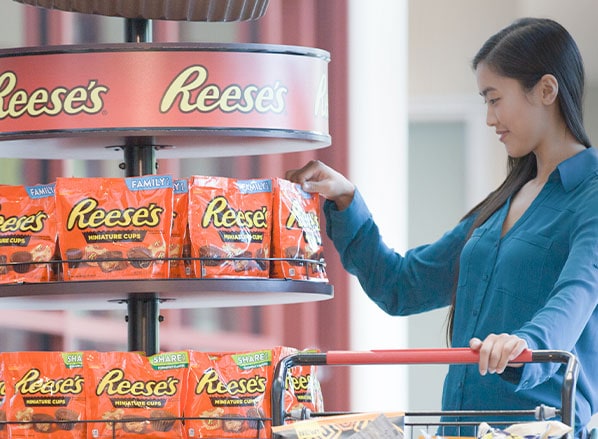 person shopping in store for reeses milk chocolate peanut butter cups